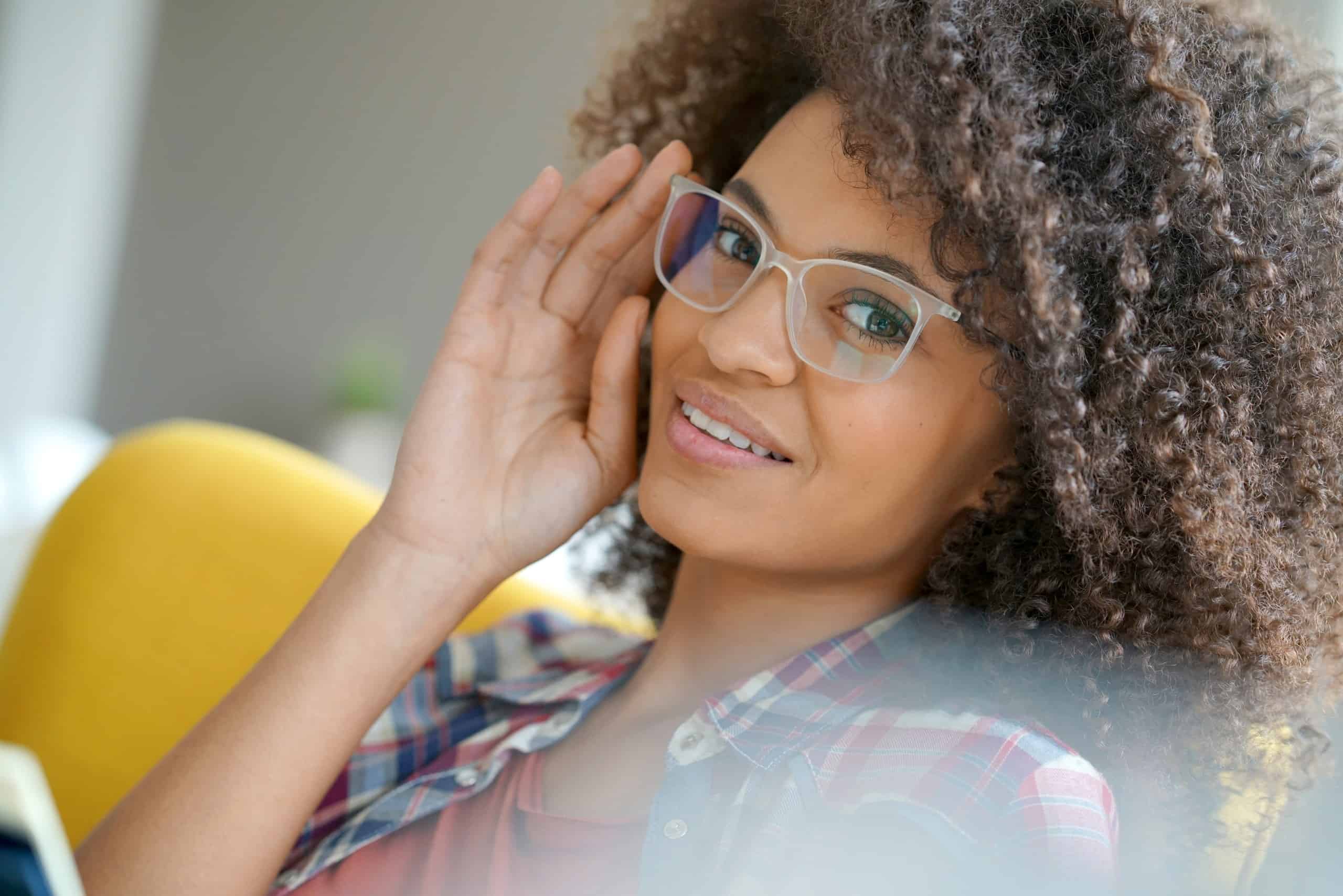 Attractive mixed race woman with eyeglasses relaxing in armchair